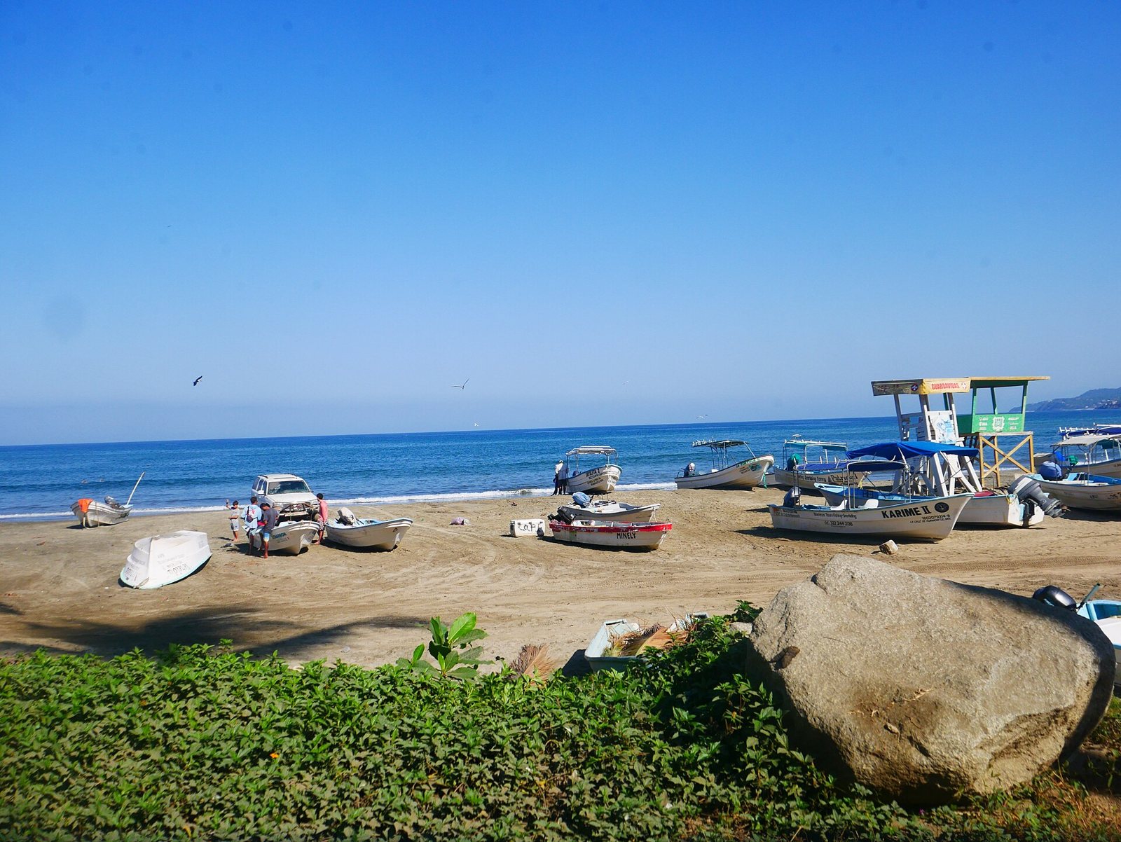 Lanchas de pescadores sobre la arena y una torre de salvavidas en la playa de Sayulita