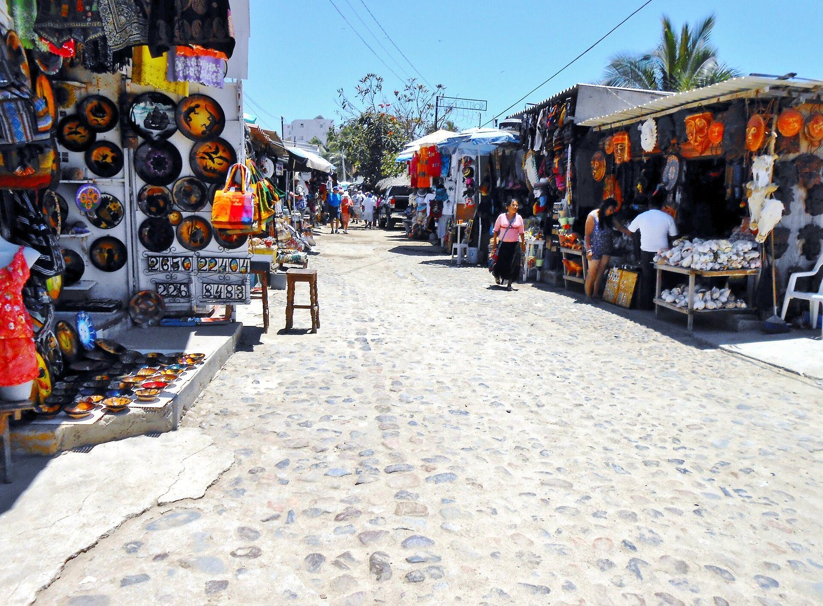 Puestos de artesanías mexicanas a lo largo de una calle empedrada en Bucerías
