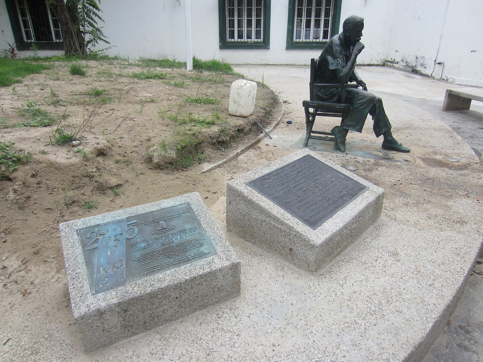 Estatua de bronce de John Huston sentado en una silla de director, con placas conmemorativas, en Puerto Vallarta