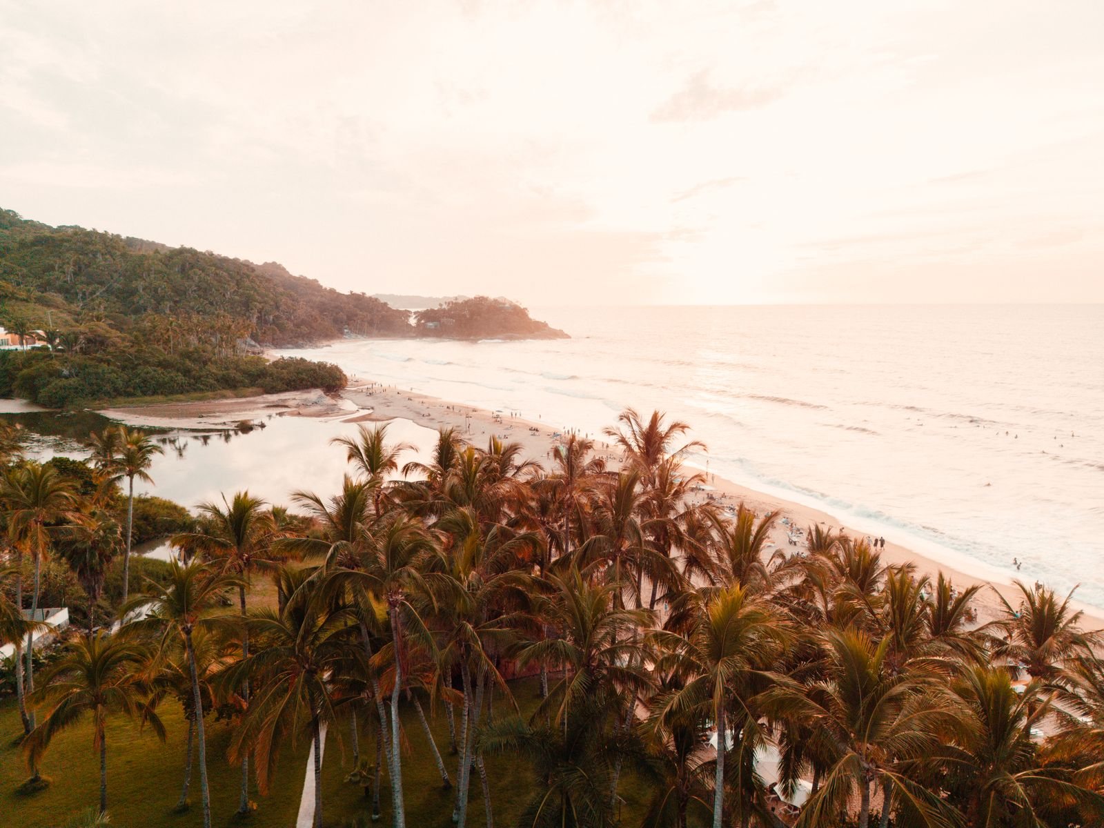 Vista aérea de la playa de San Francisco, Nayarit, al atardecer, con palmeras, el estero y el cerro al fondo