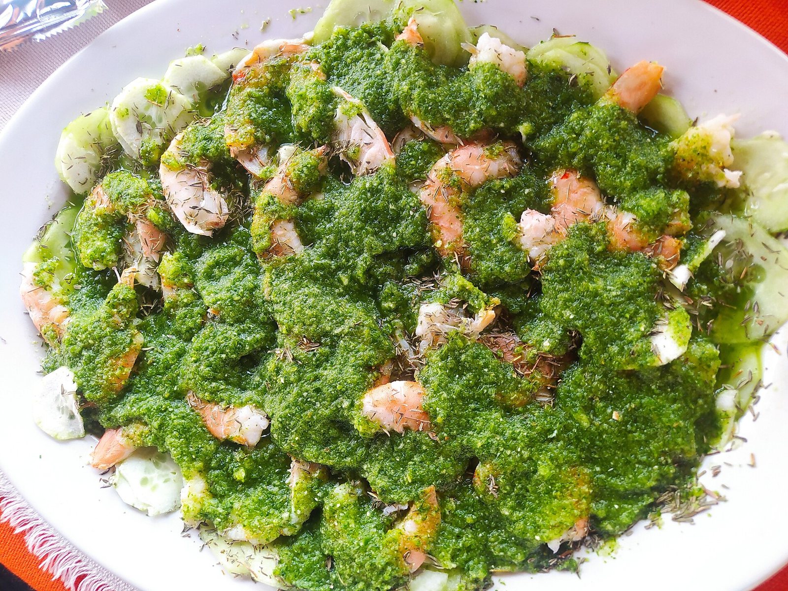 Plato de aguachile verde con camarones cubiertos de salsa de chile verde sobre rodajas de pepino