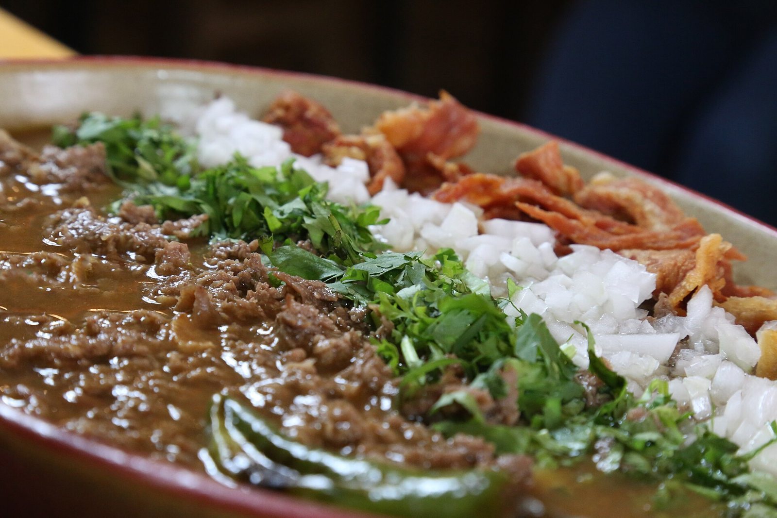 Cazuela de carne en su jugo con carne picada en caldo, cilantro, cebolla picada y tocino dorado