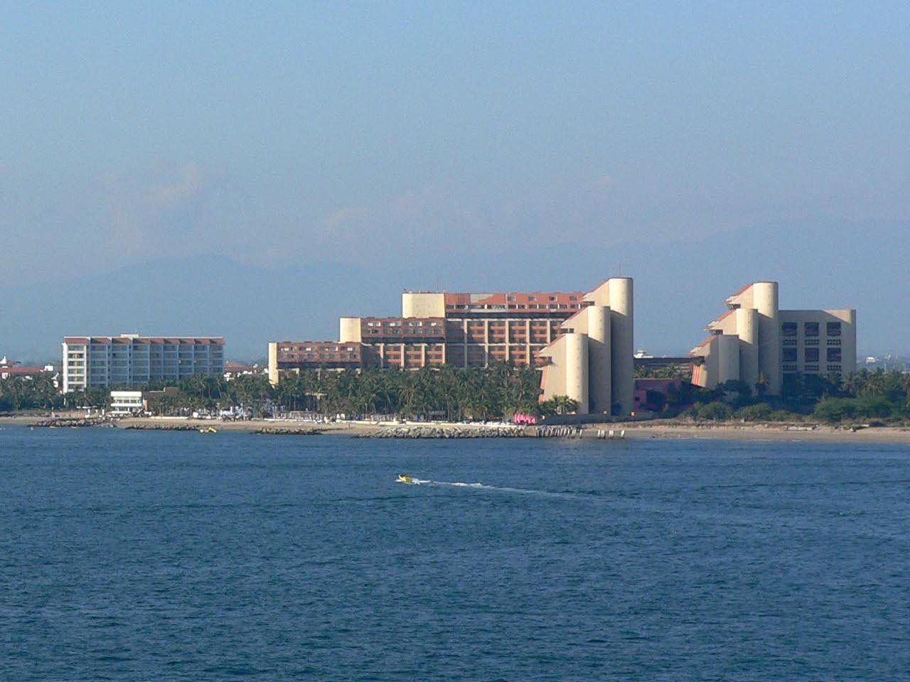 Edificios del hotel The Westin Resort & Spa Puerto Vallarta vistos desde el mar, con torres de formas curvas, palmeras y la playa